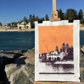 Photograph of a Cottesloe Beach tea towel on an easel.